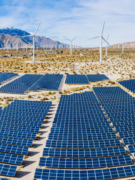 A field of solar panels and windmills in the desert.